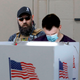 Image for article titled ‘Poll Watching Is Not Voter Intimidation,’ Trump Supporter Whispers Into Ear Of Man Filling Out Ballot In Voting Booth